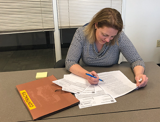 A Dane County employee signs a contract